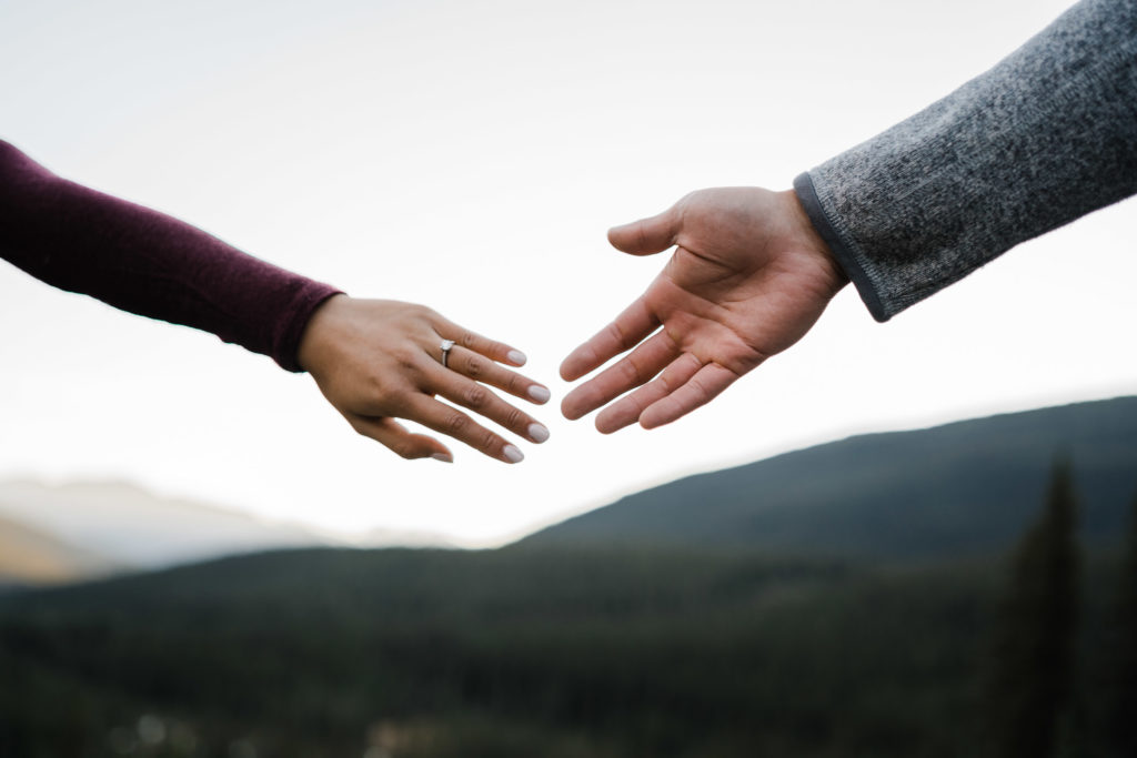 Engaged couples outstretched hands showing engagement ring