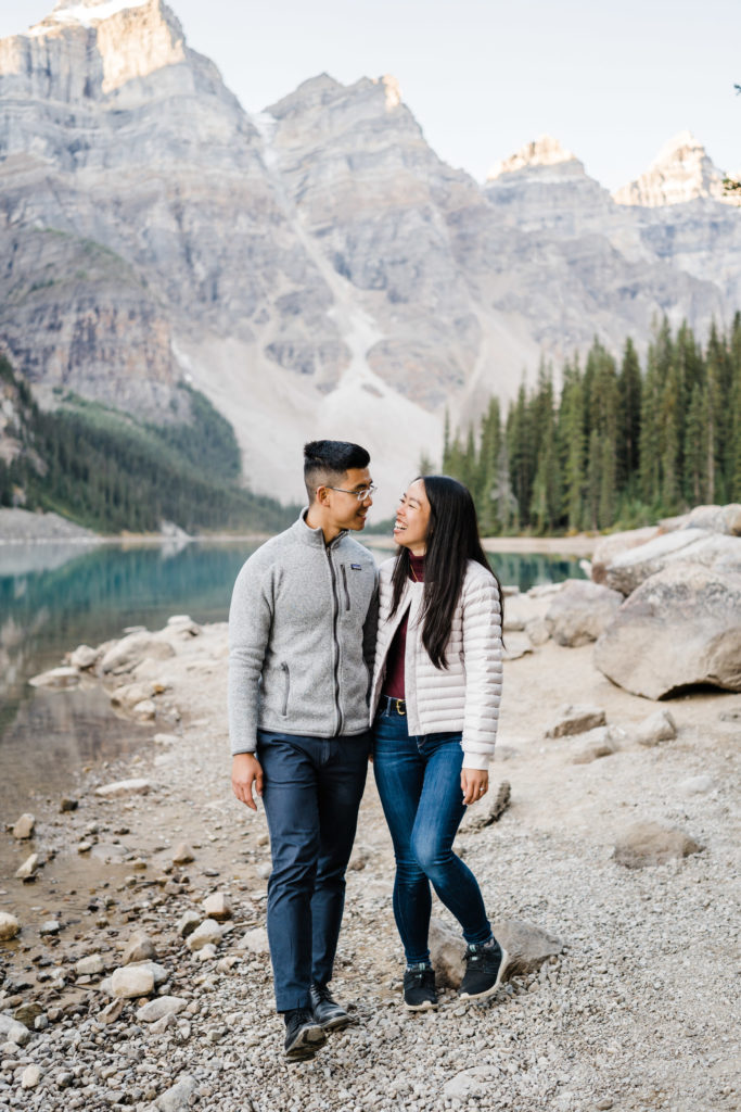 Couple casually looks at each other while walking by Moraine Lake