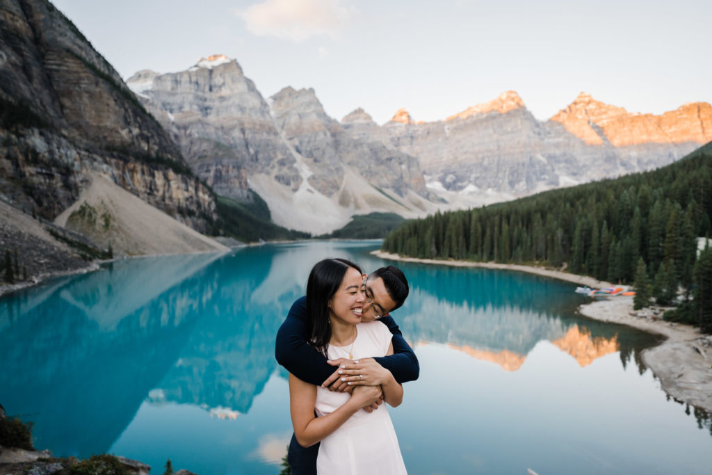 Couple snuggles together during sunrise in Banff National Park