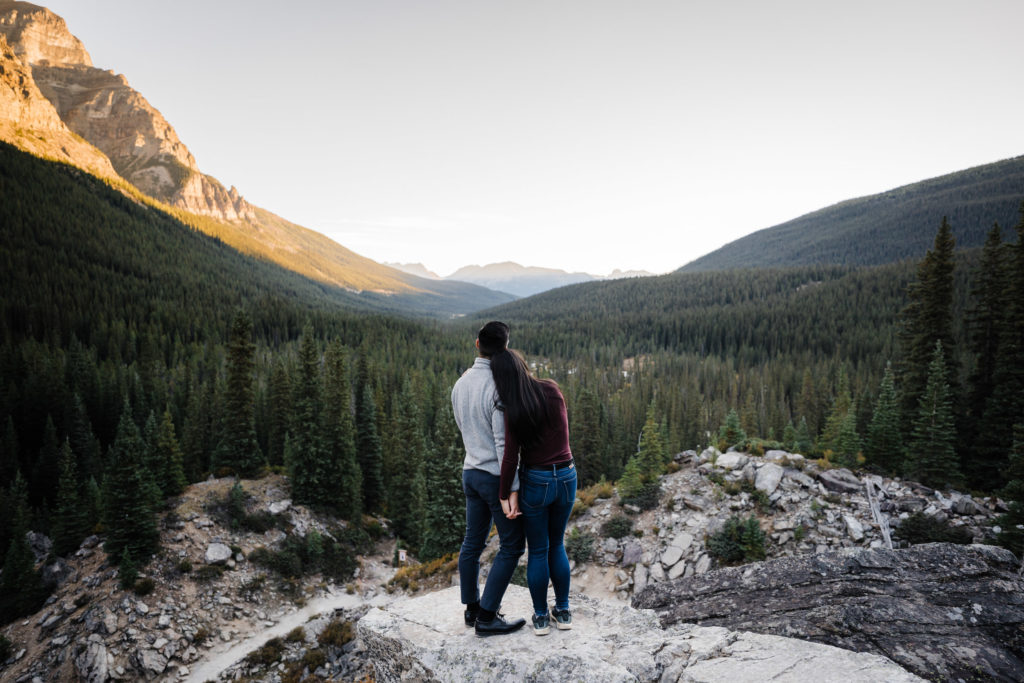 Couple looks out down the valley during sunrise