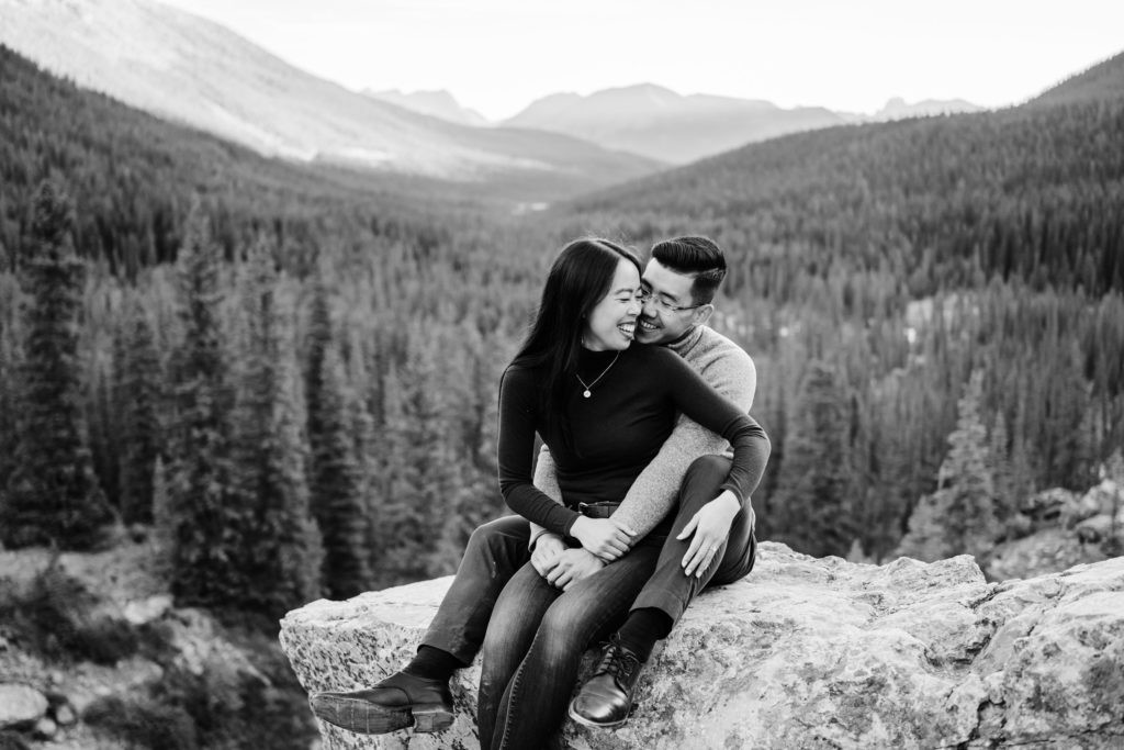 Couple cuddles on rock in Banff National Park