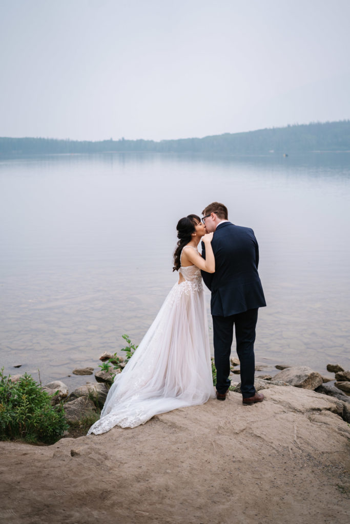 Bride and groom kiss on shores of Pyramid Lake