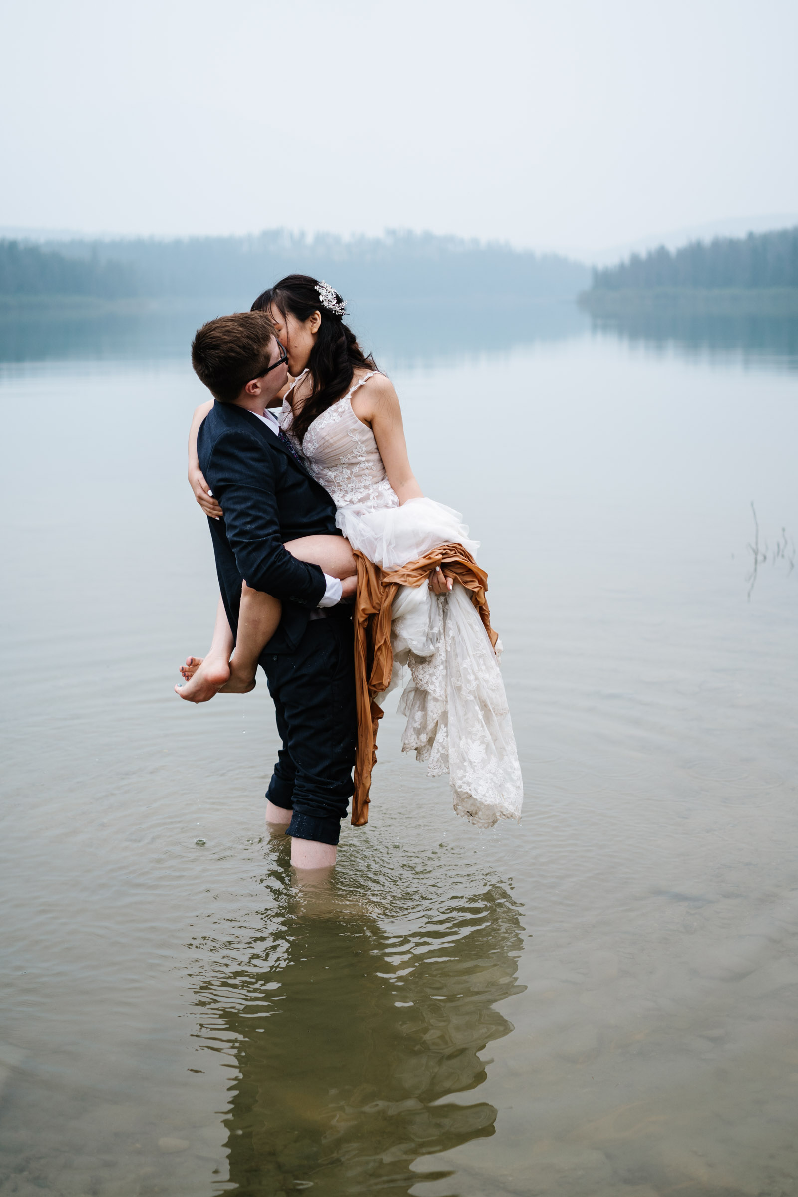 Groom holds bride in water during Jasper Elopement