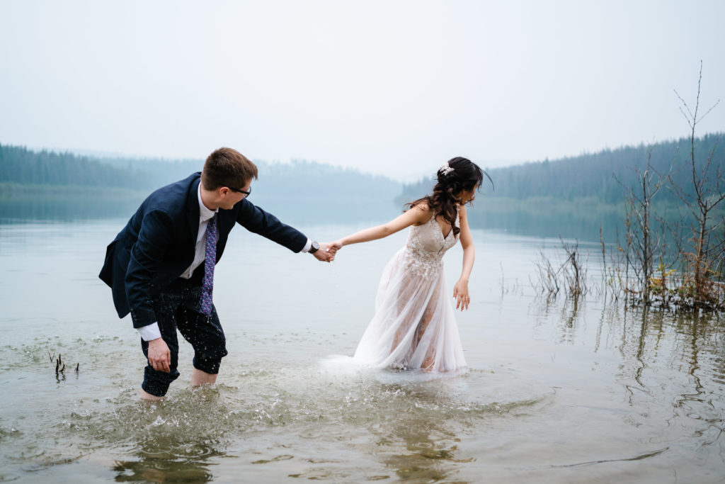 Bride and groom splash each other in Patricia Lake