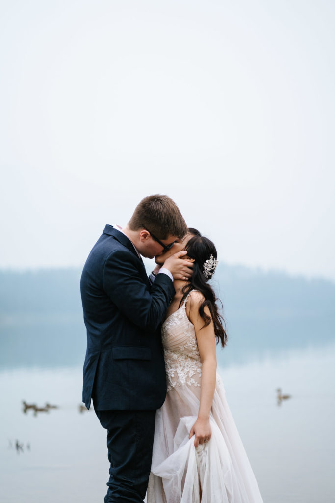 Groom kisses bride during elopement at Patricia Lake
