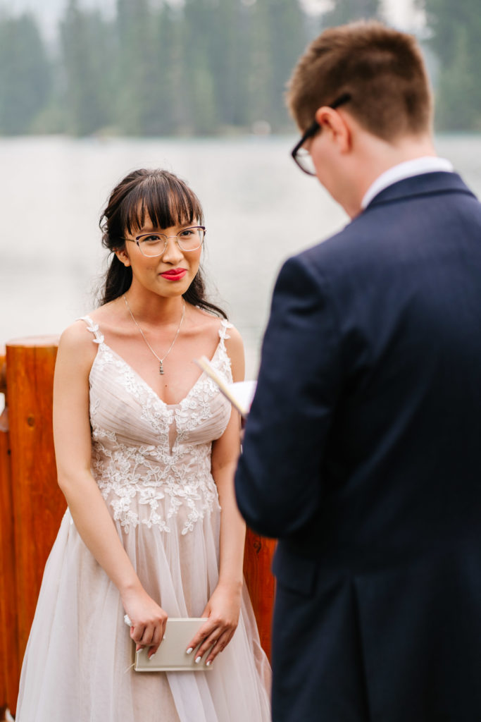 Bride looks at Groom as he reads her his vows 