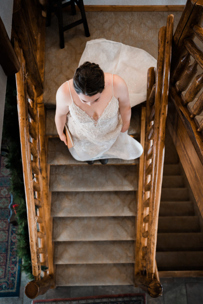Bride walks down the stairs at A Bear and Bison Inn to go meet up with her future wife for a first look. 
