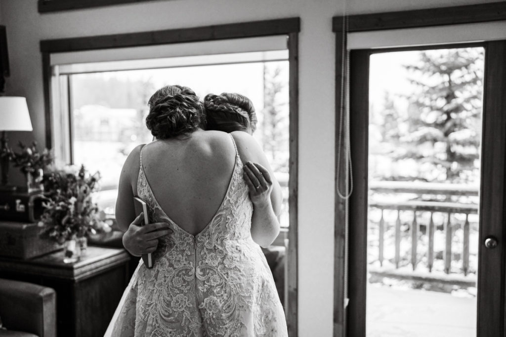 Two brides embrace after a first look at A Bear and Bison Inn in Canmore. 