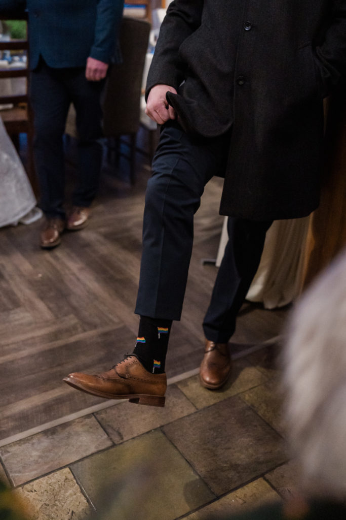 Man shows off pride socks for winter lgbtq+ wedding in Canmore Alberta.