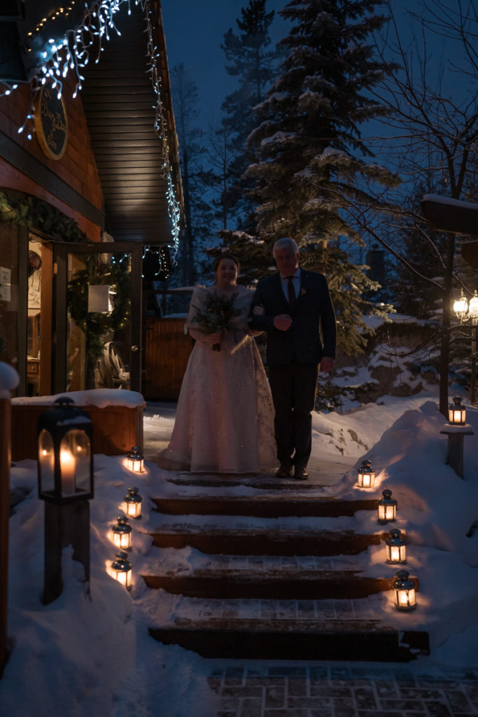 Bride walks down stairs at A Bear and Bison Inn. 