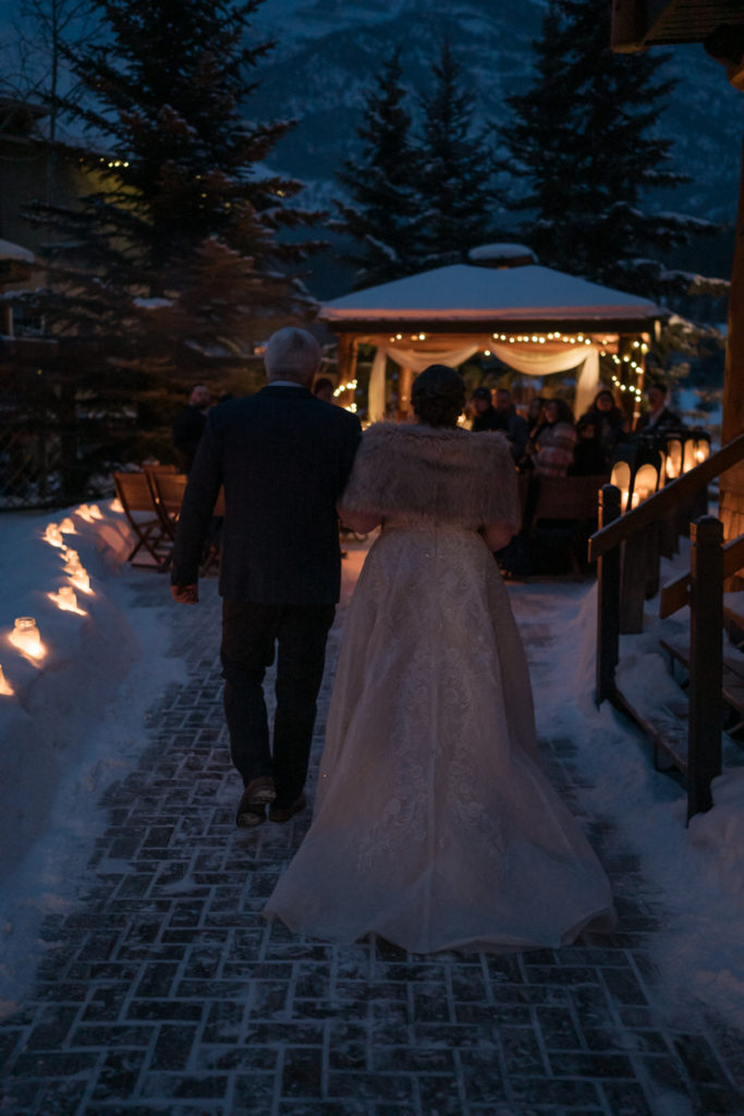 Bride walks towards bride in outdoor sunset ceremony in Canmore Alberta