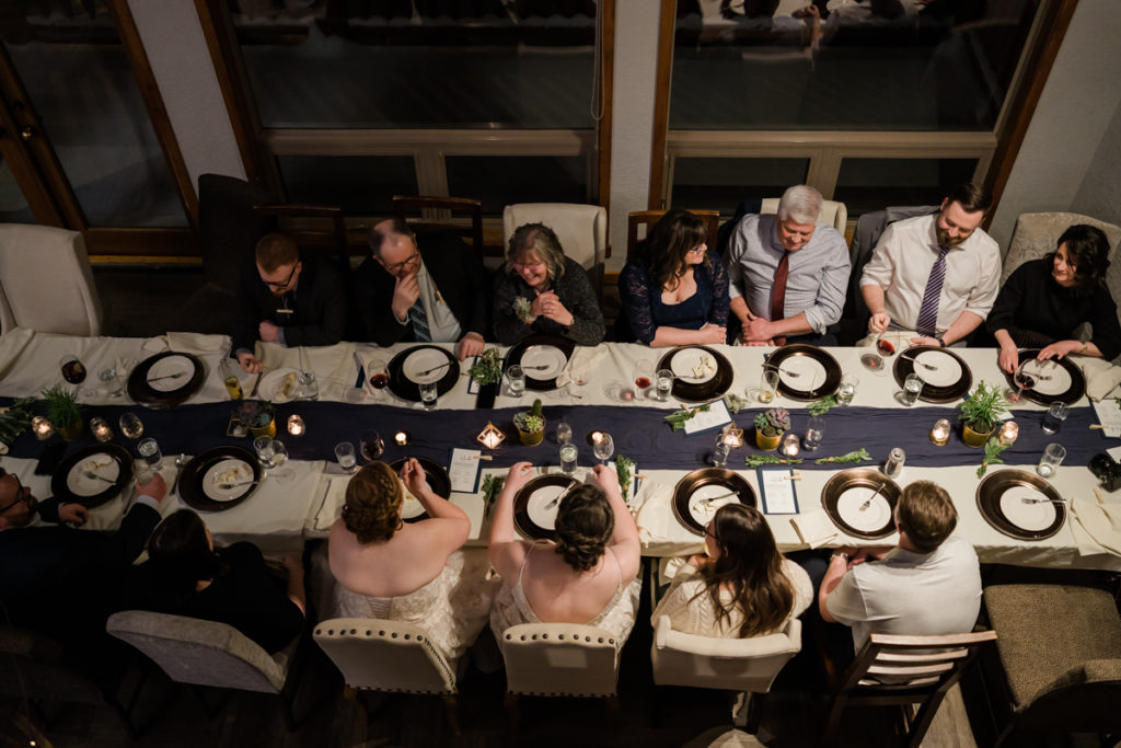 Two brides eat dinner with their families at A Bear and Bison Inn in Canmore