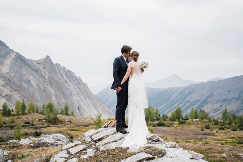 Bride and groom embrace in Arethusa Cirque during their fall hiking elopement in Kananaskis. 