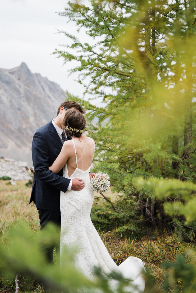 Bride and groom kiss in the larch trees in Arethusa Cirque. 