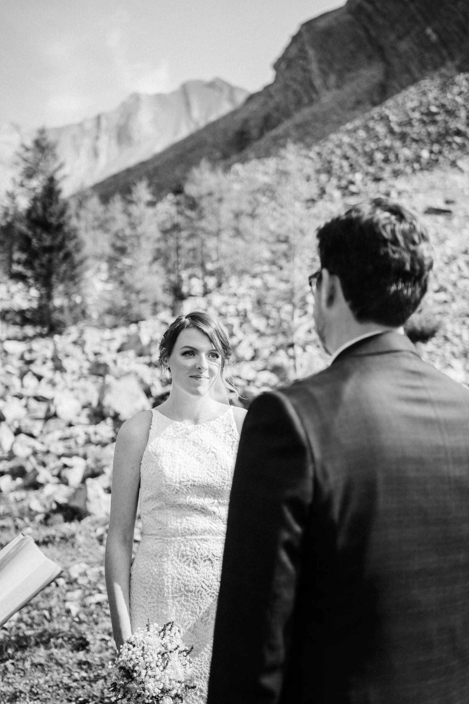 Black and white photo of bride looking at groom during ceremony. 