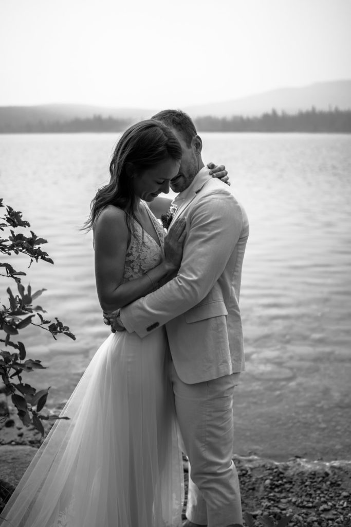 Black and white photo of a loving embrace with the bride's hand on the groom's chest in Jasper National Park.
