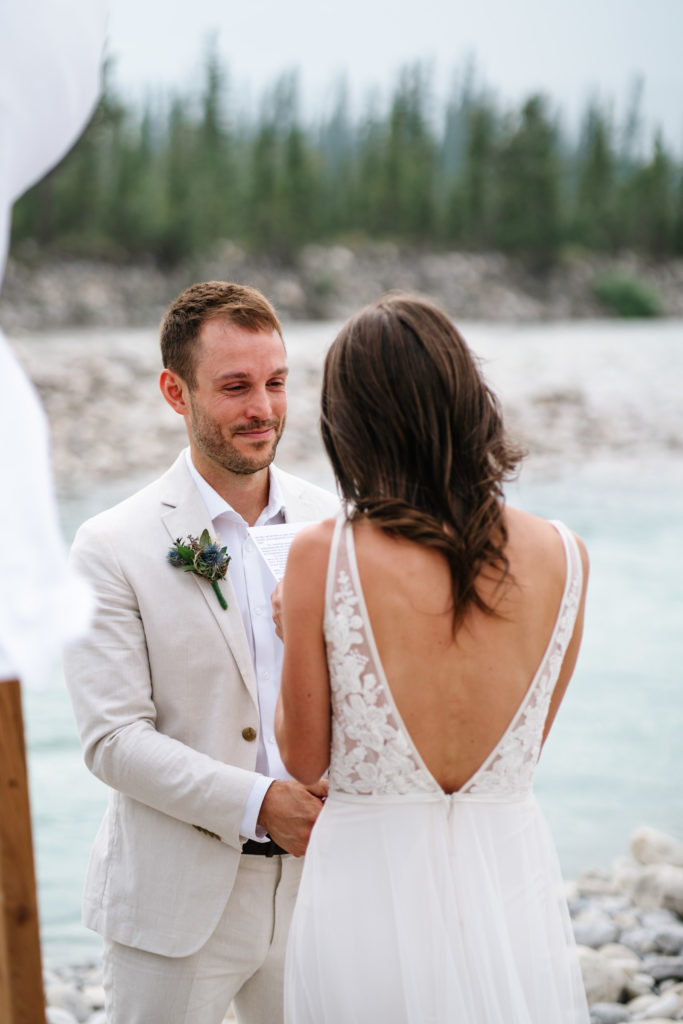 groom cries as bride reads her personalized vows during Jasper intimate wedding ceremony. 