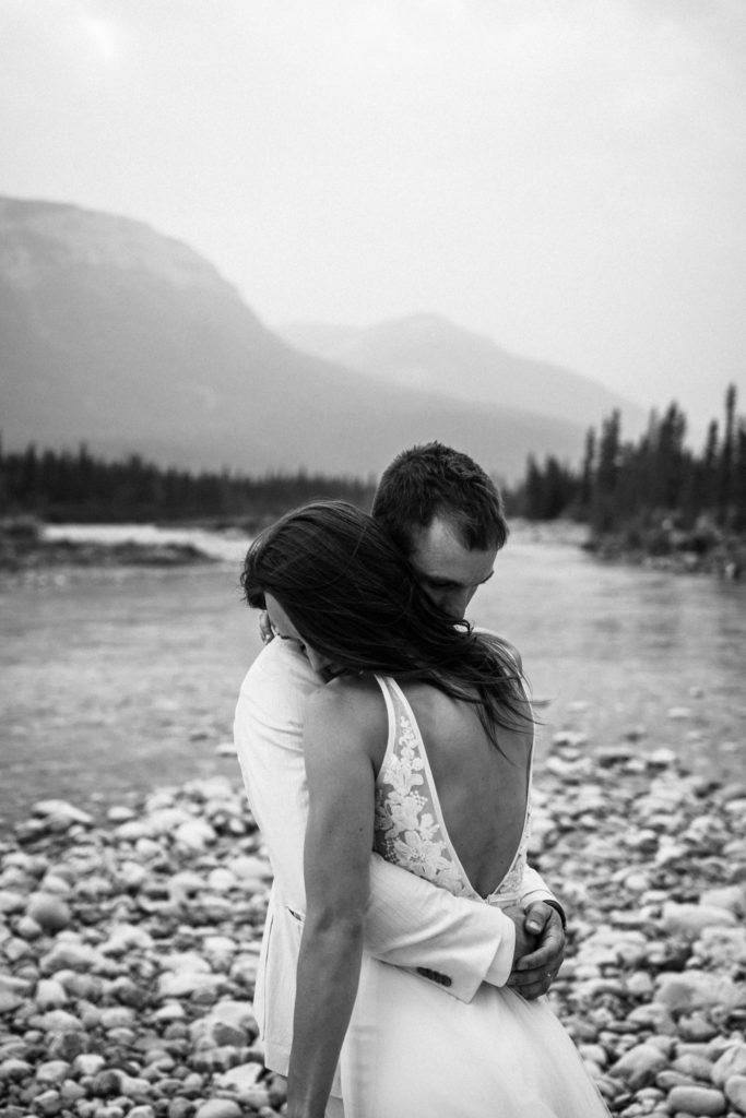 Black and white photo of bride and groom hugging in Jasper National Park. 