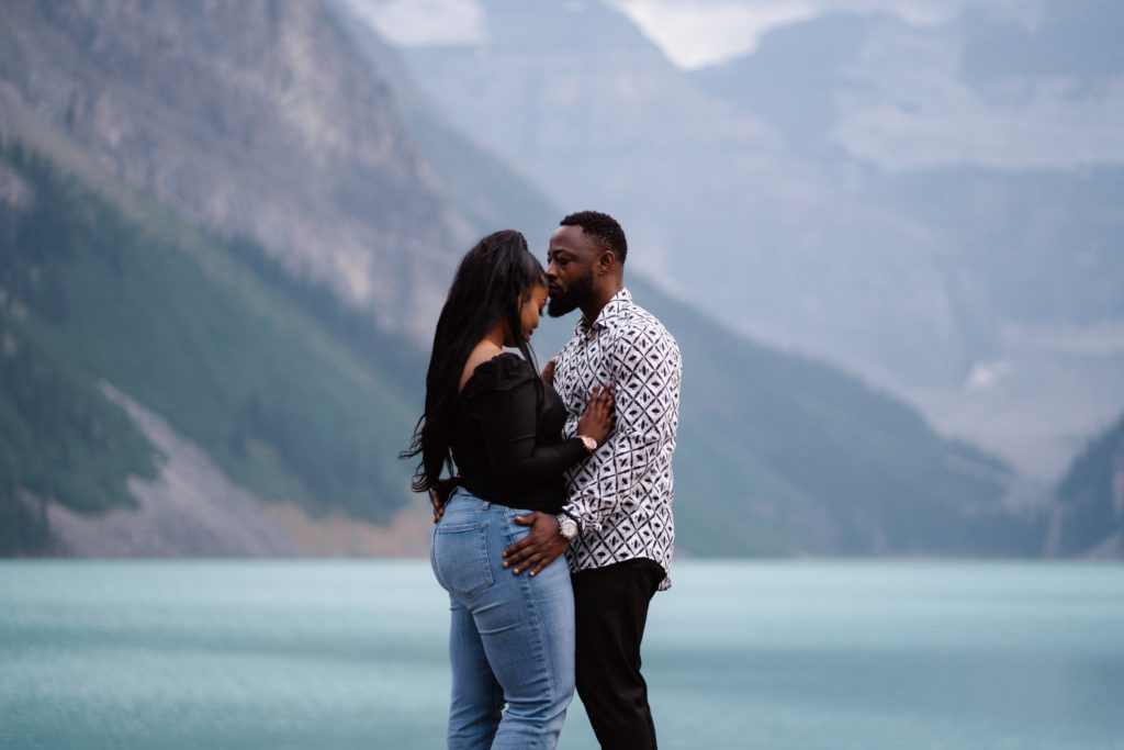 Man kisses girlfriends forehead in Banff National Park