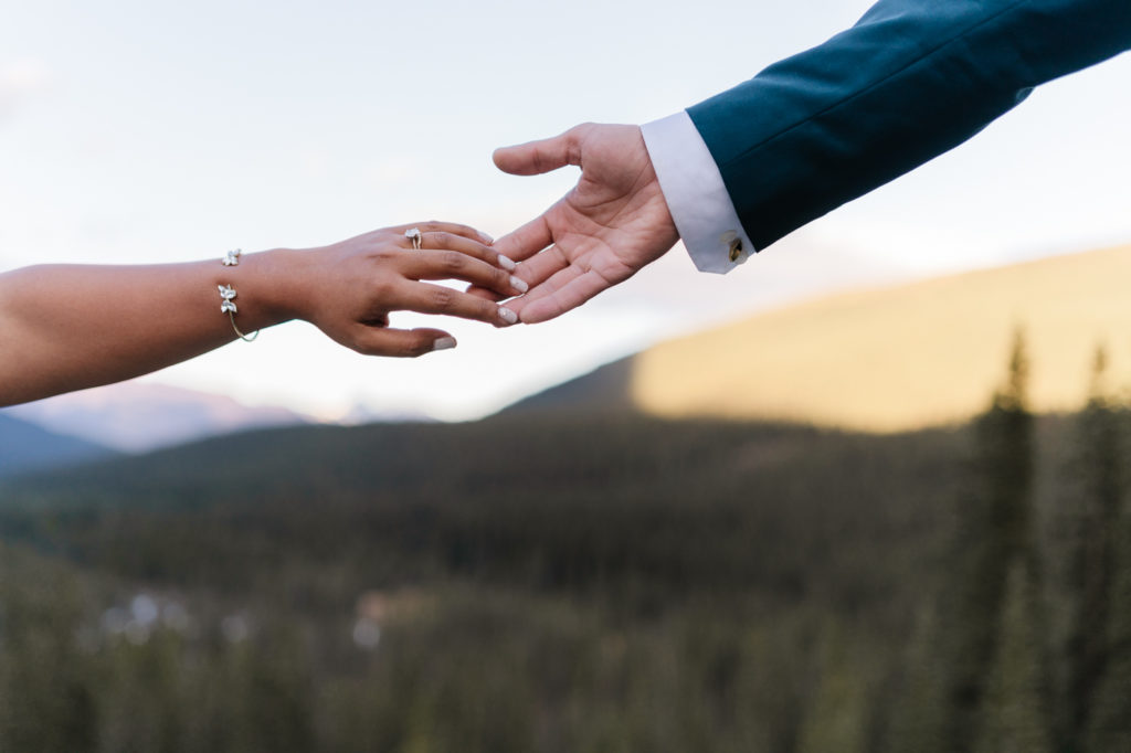 Bride and grooms hands touch slightly in Banff National Park