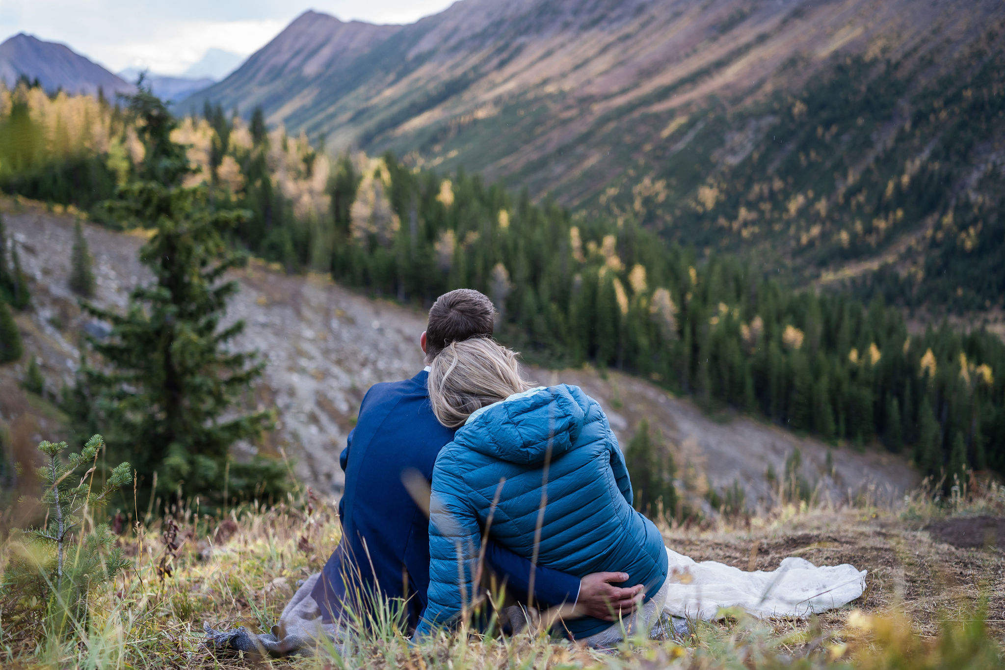 bride and groom cuddle up on blanket as the sunsets in Kananaskis
