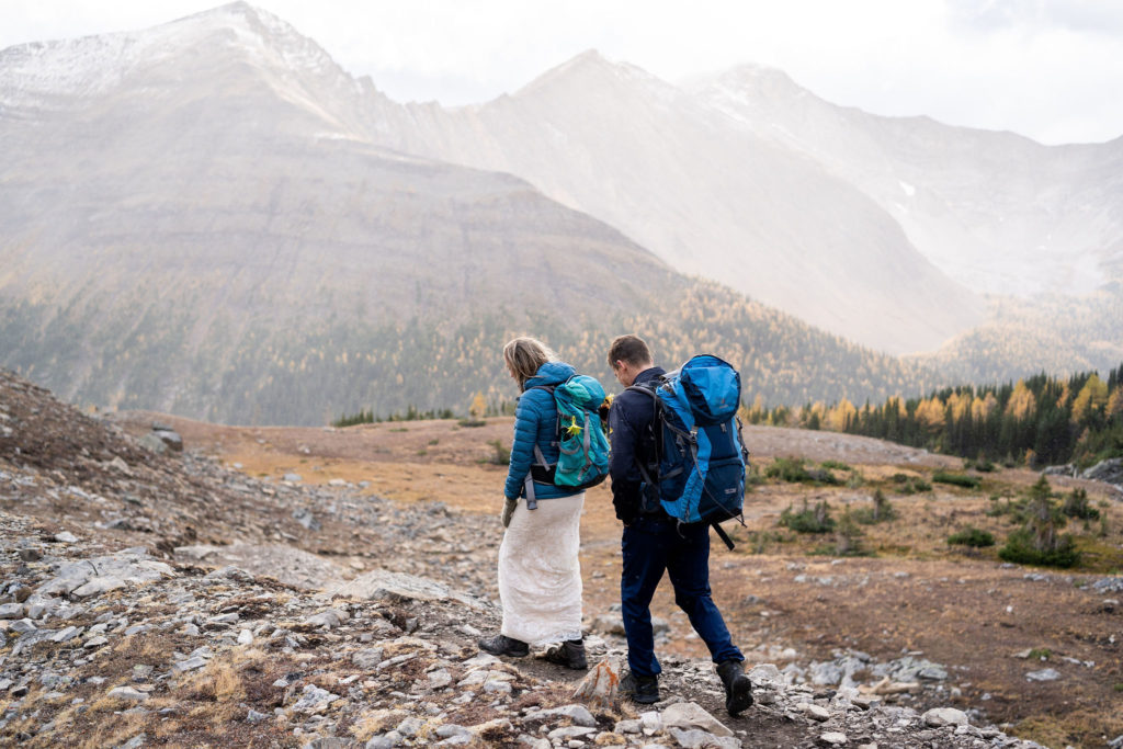 Bride and groom walk down Ptarmigan Cirque trail in the fall