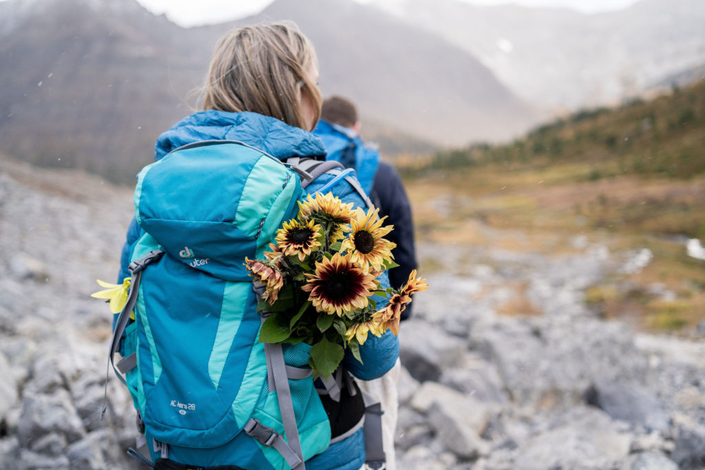 Bouquet of sunflowers in deuter backpack during hiking elopement