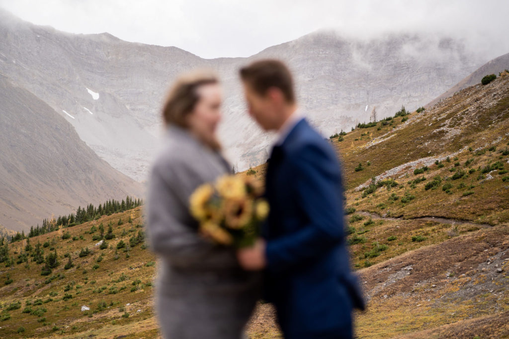 Bride and groom blurry as the focus is on the background of Ptarmigan Cirque