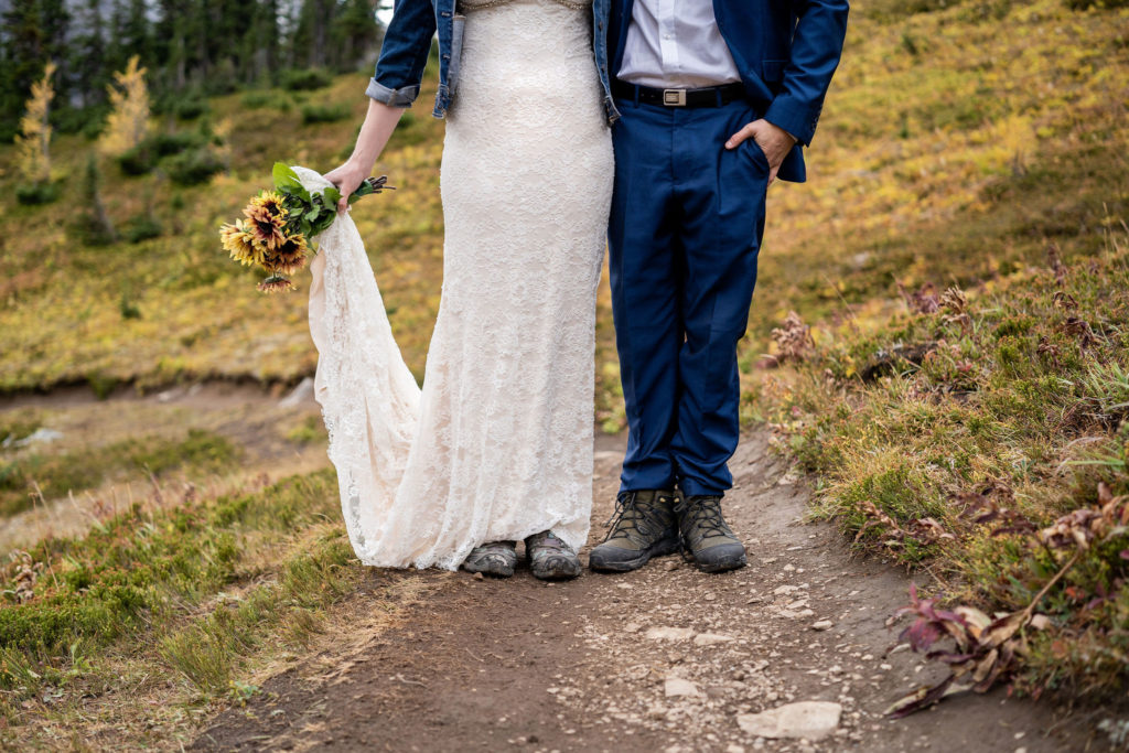 Close up shot of bride and grooms hiking boots as they stand on the trail in Kananaskis