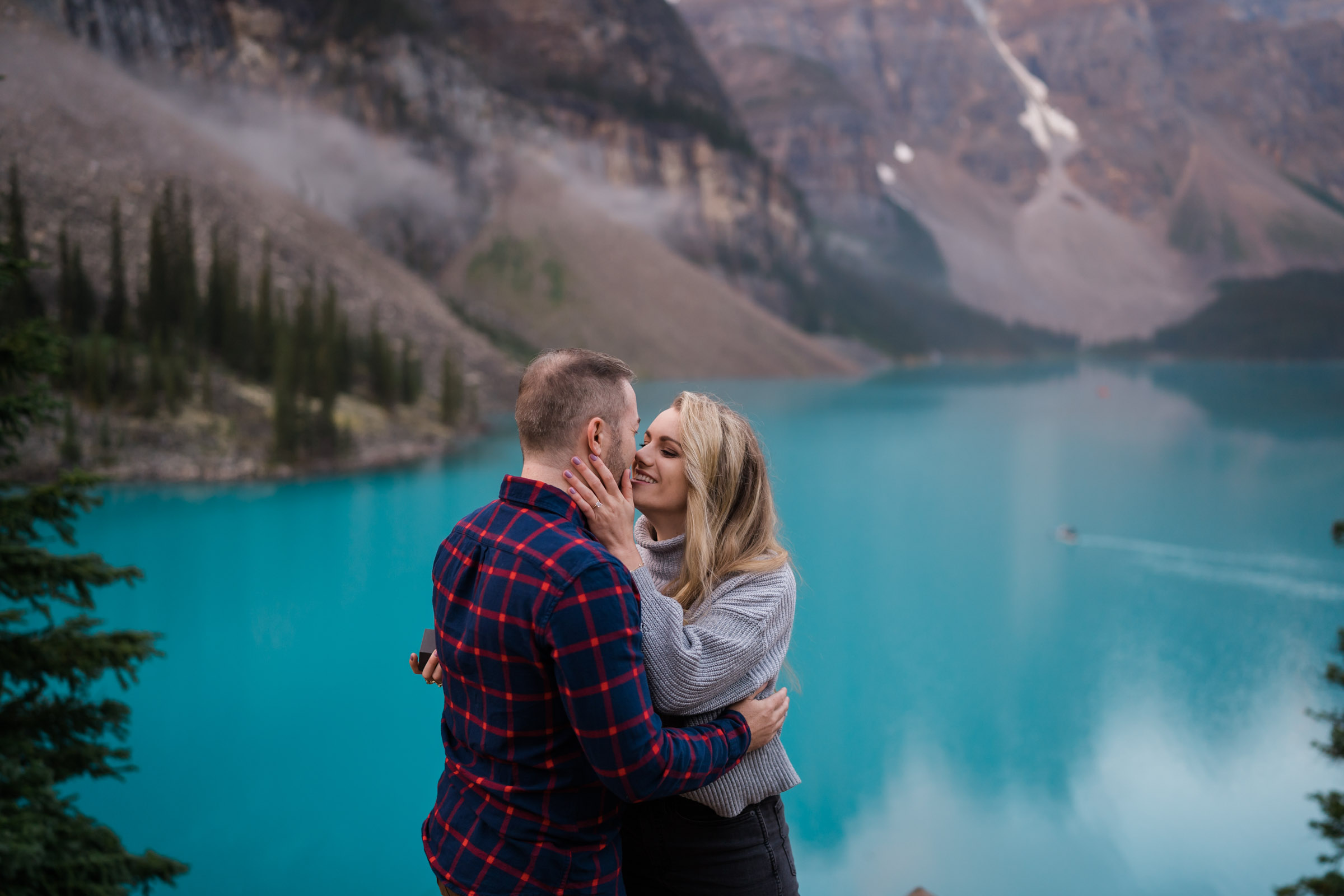 Couple kisses at Moraine lake after surprise proposal.