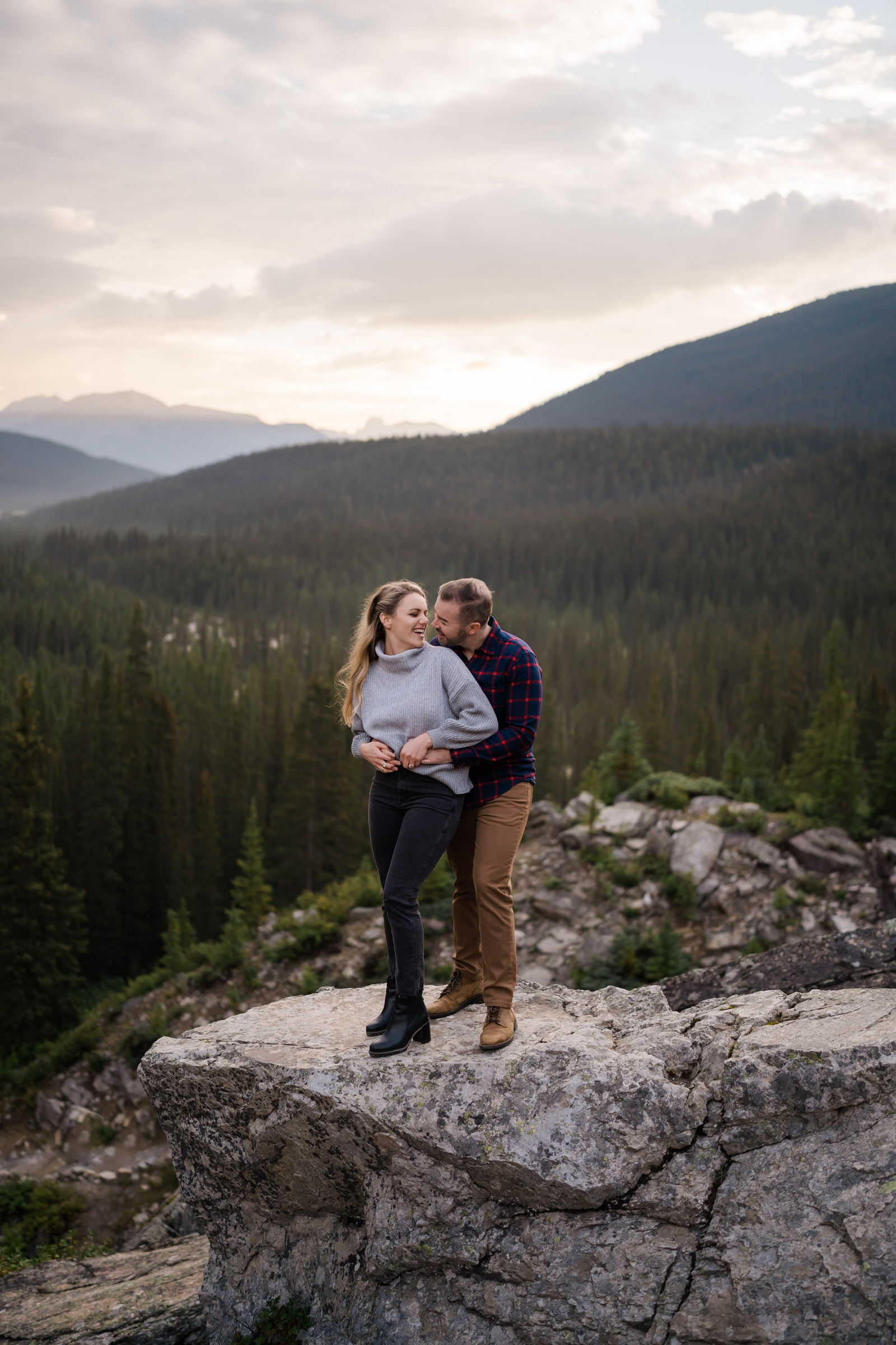 Couple snuggles and laughs during Banff engagement photos. 