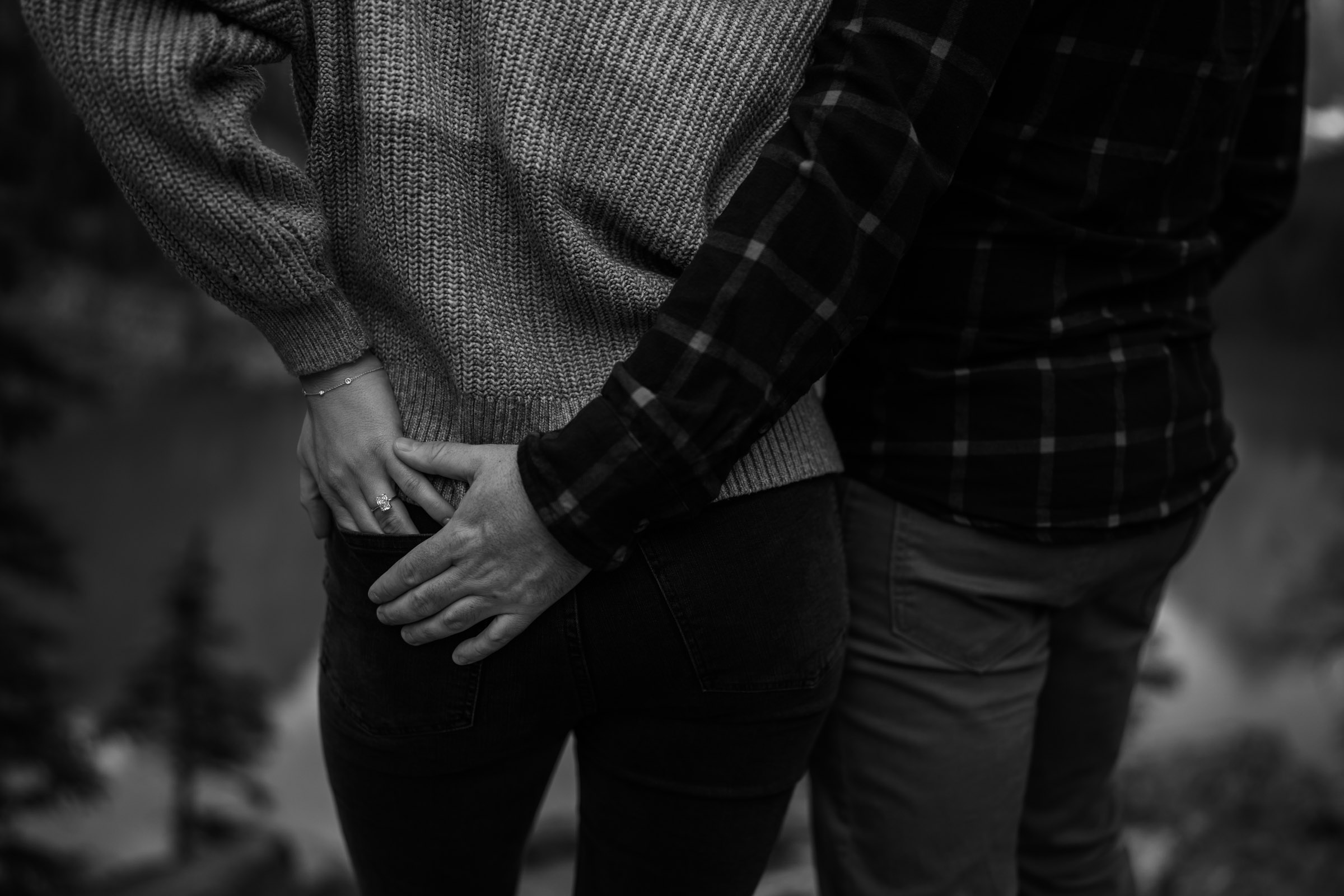 Black and White photo of hands in the back pocket of her Levi jeans showing off her engagement ring. 