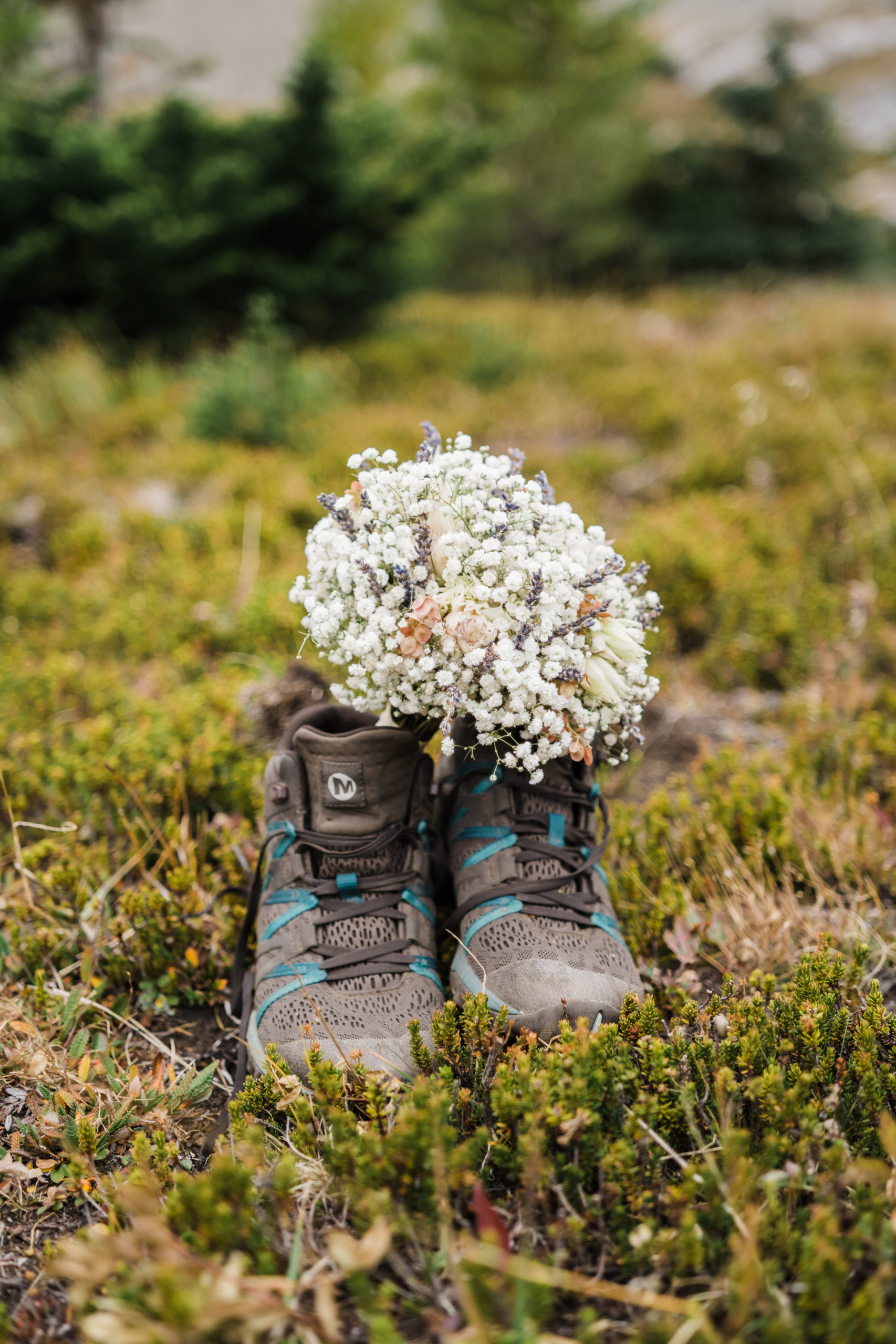 bouquet of babys breath perched in merrel hiking boots during alberta hiking elopement