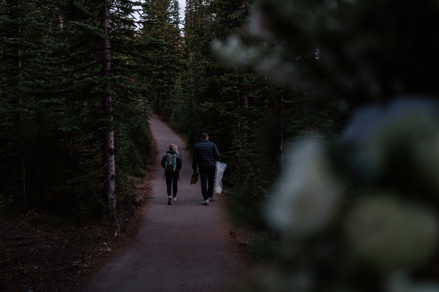 Bride and groom walk up pathway in the dark before their sunrise elopement in Banff National Park