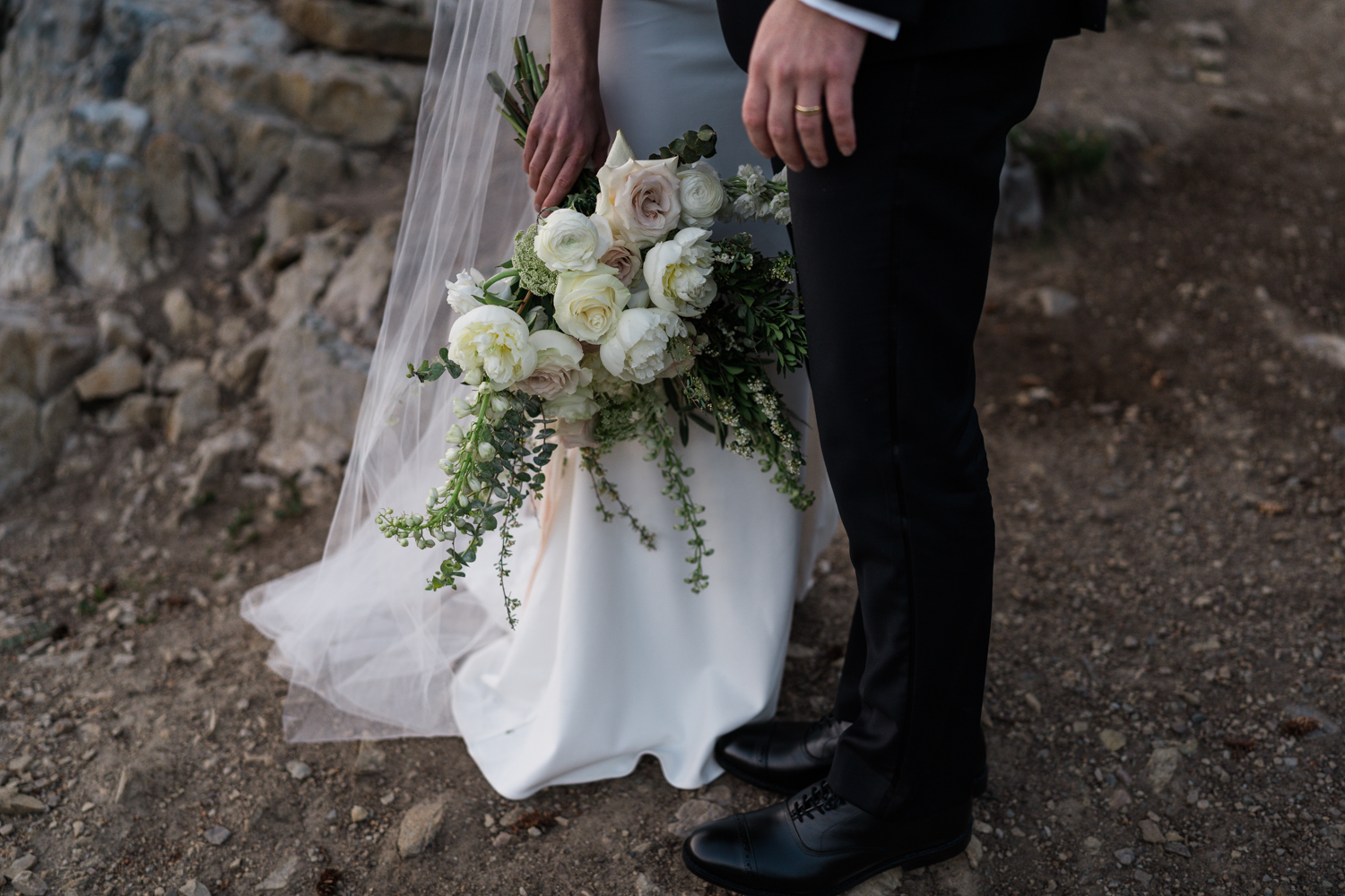 Close up of the brides bouquet and groom with his ring on his hand during sunrise elopement in Banff