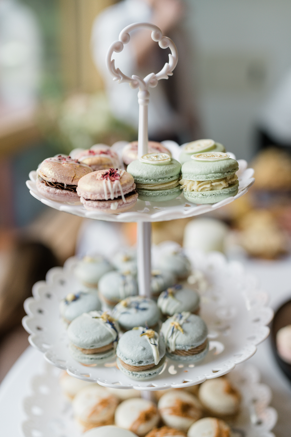 handmade macroons on white cupcake stand 