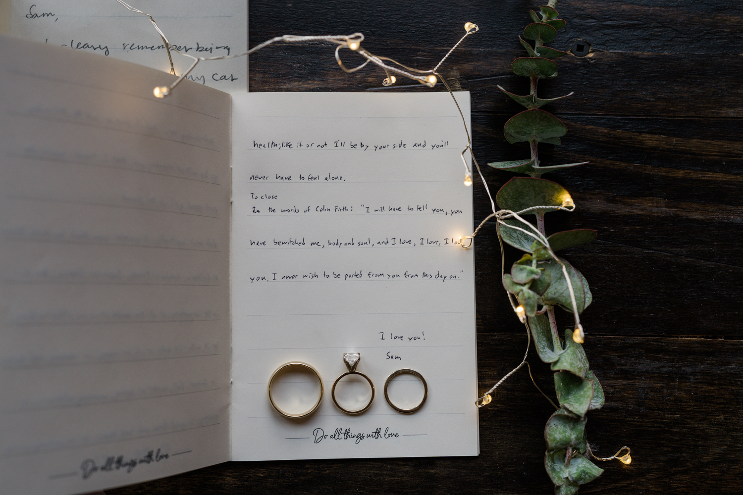 vow book open to the last page with the rings and greenery and twinkly lights surrounding it in Banff National Park