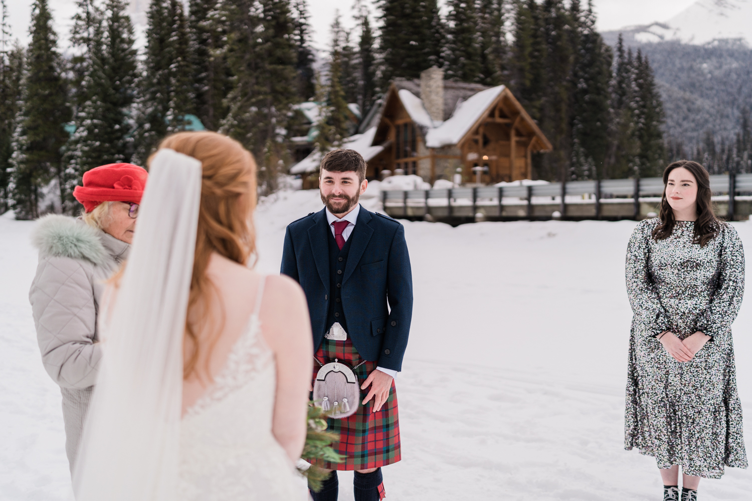 groom smiles at bride during a winter wedding ceremony at Emerald Lake