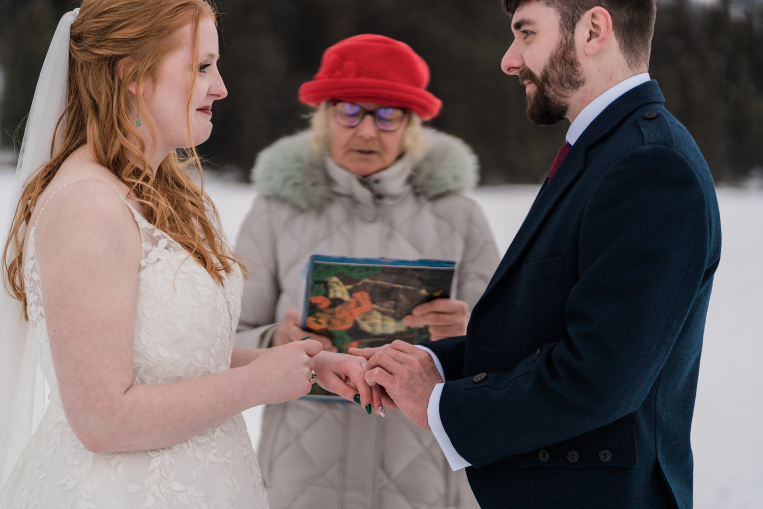Groom places the ring on a brides finger during a Emerald Lake elopement