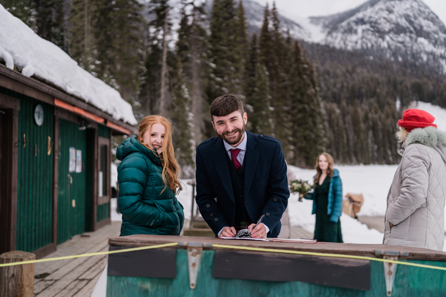 groom signs wedding documents at emerald lake lodge