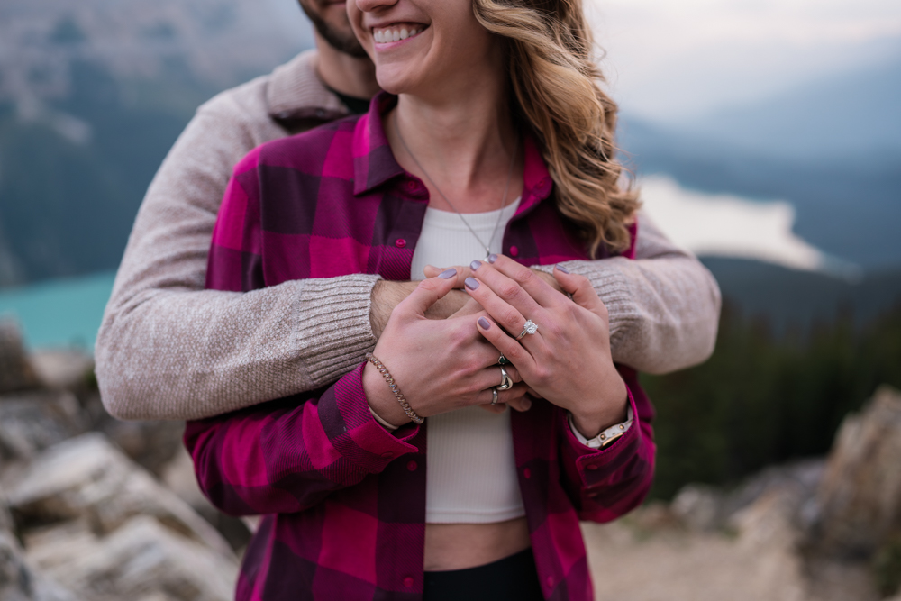 close up of hands cuddling around two people showing off a new engagement ring after a Peyto Lake proposal
