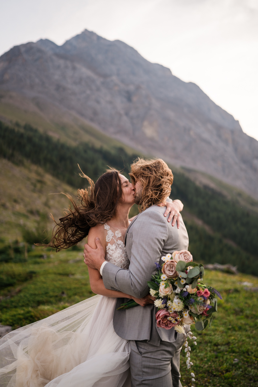 A couple's joyful embrace captured in the stunning landscape of an Alberta elopement in Kananaskis.