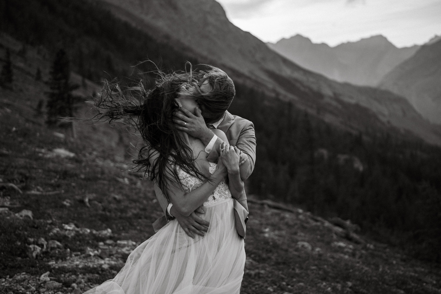 A tender moment between the couple captured at sunrise during their backcountry camping elopement in Kananaskis.