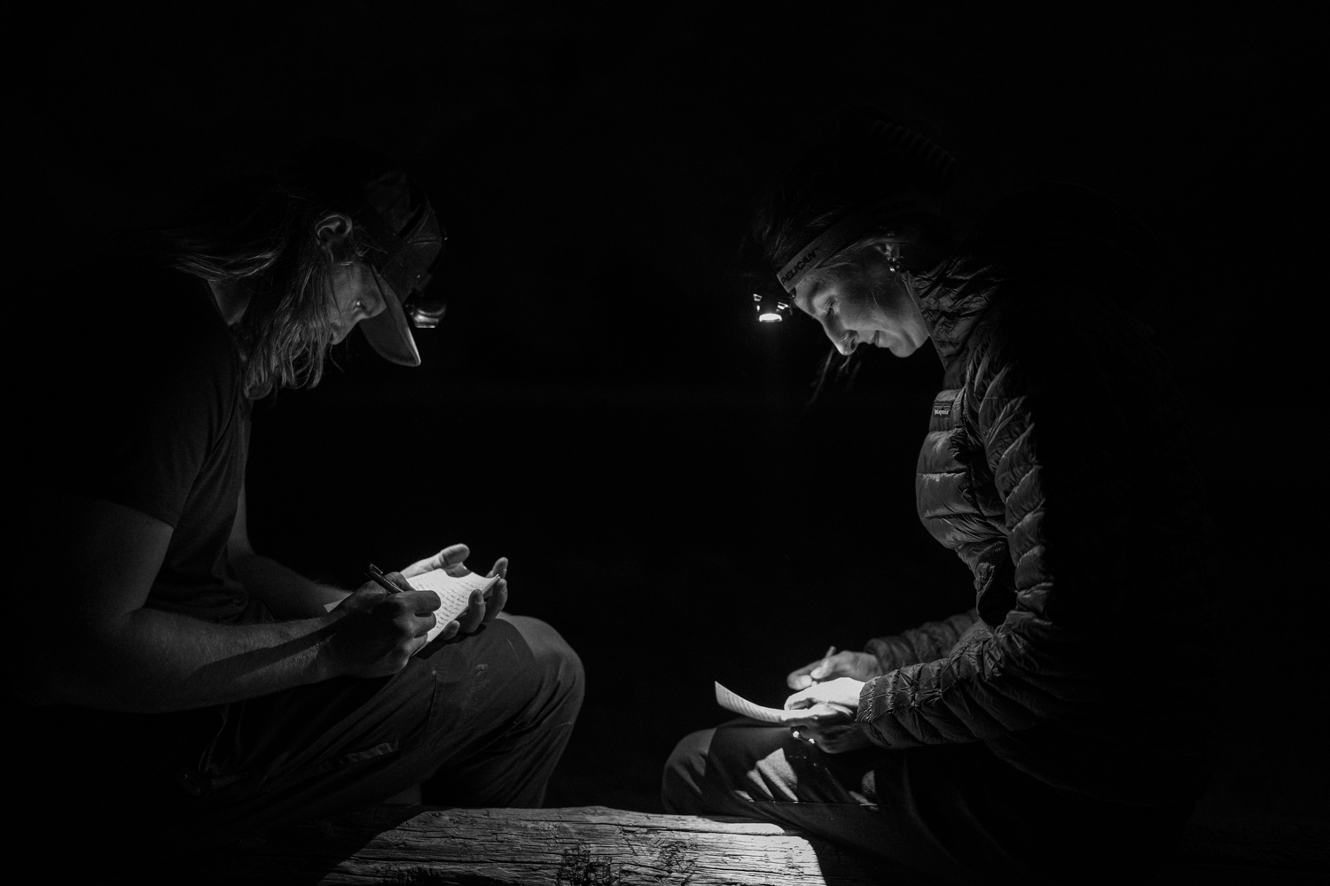 Vow writing together by headlamp during an Alberta camping elopement. 