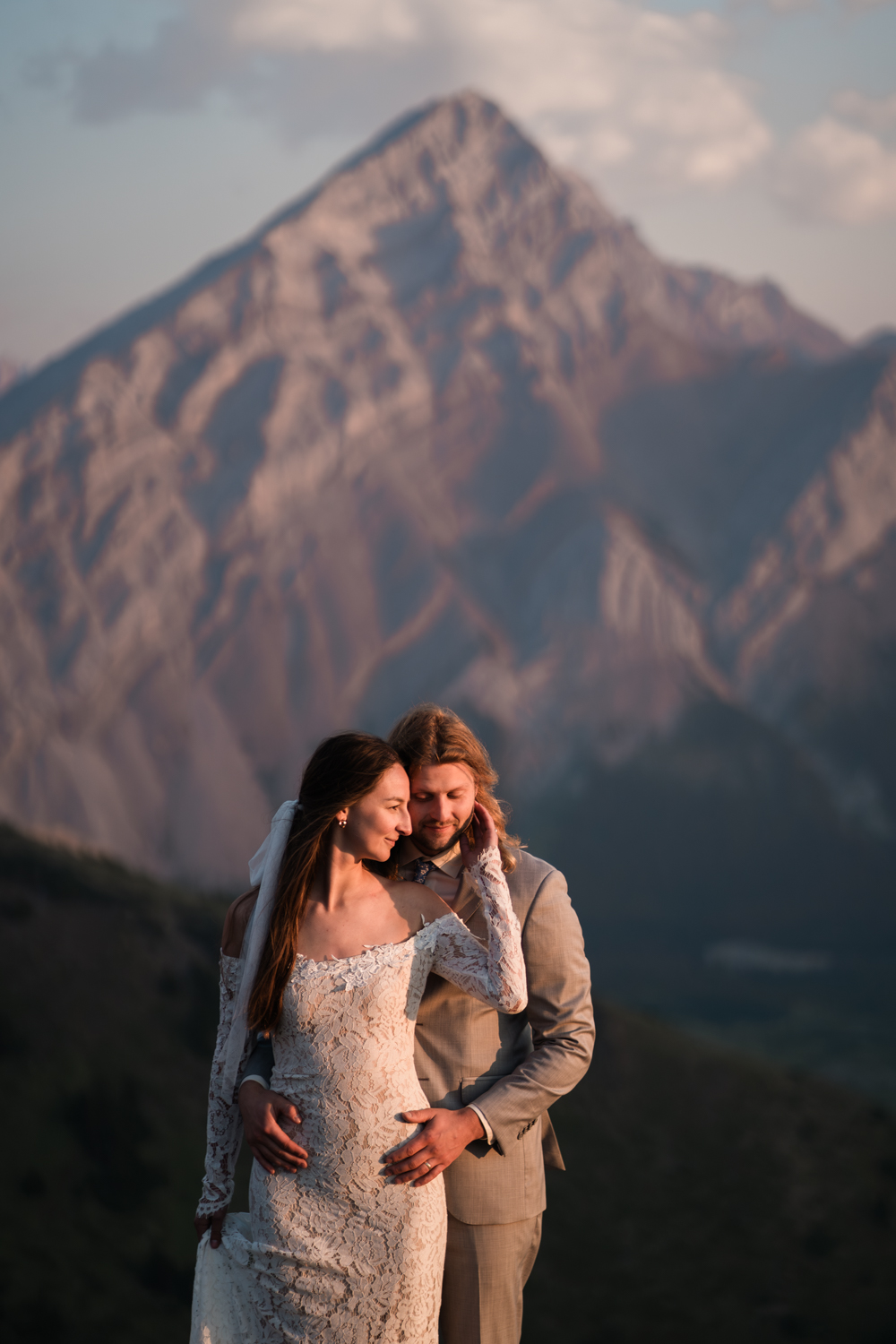 The warm glow of the sunrise illuminating a couple's love during their Kananaskis backcountry camping elopement