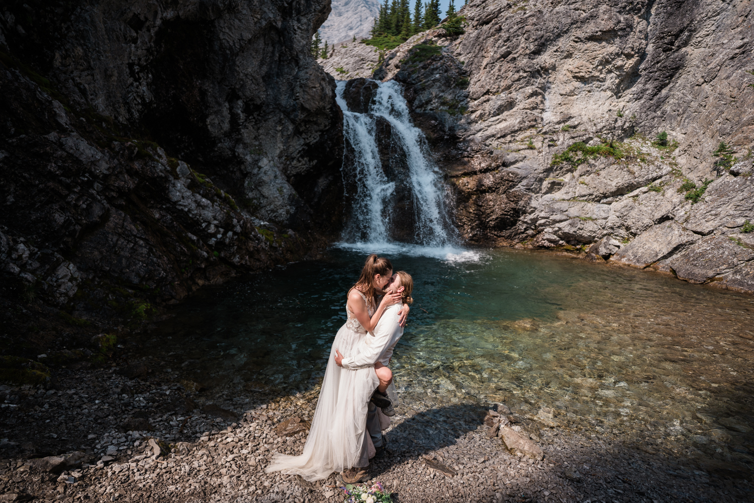 bride and groom kiss at Elbow Falls during their Kananaskis elopement