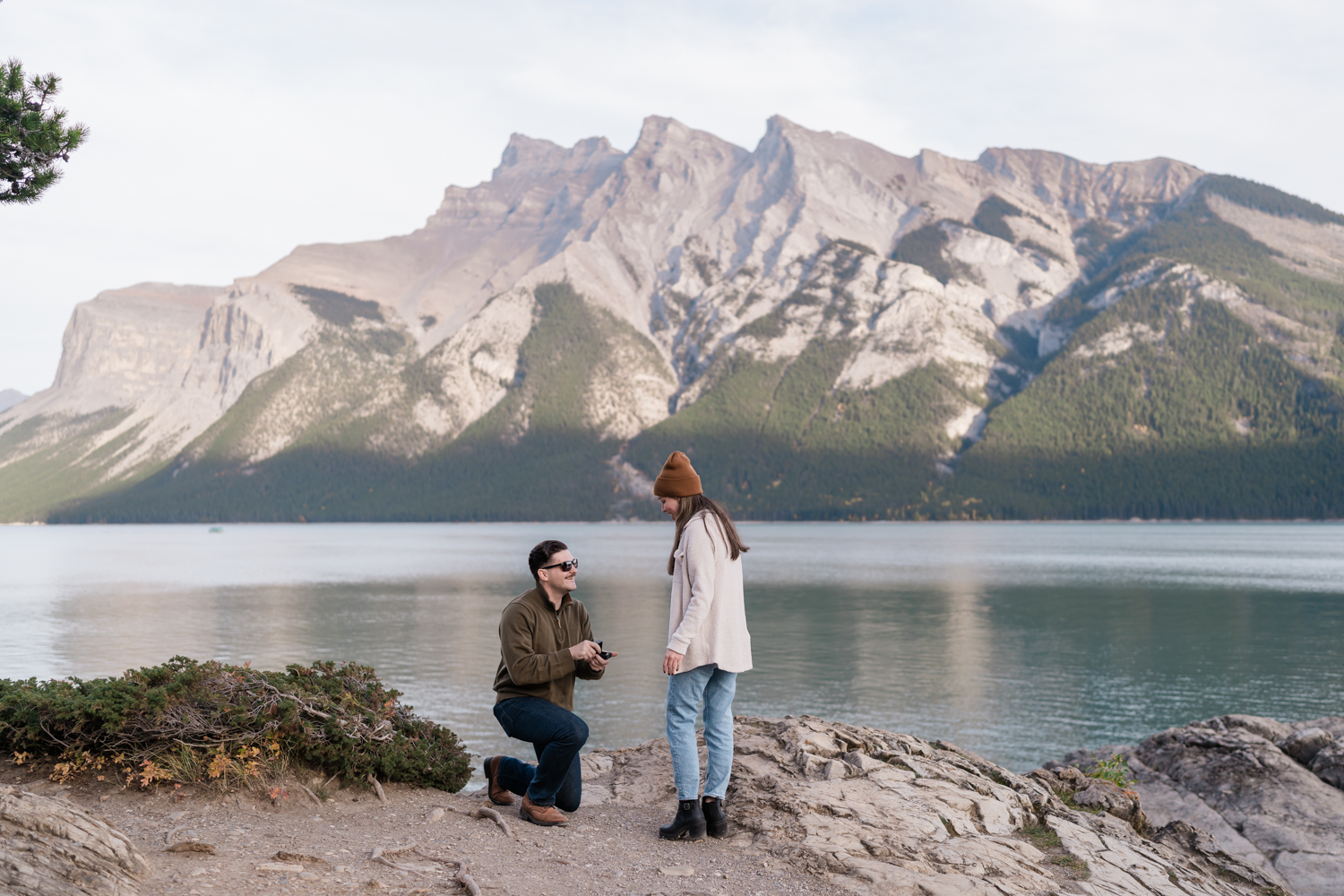 Man proposing to his girlfriend at Lake Minnewanka before taking Banff engagement photos. 