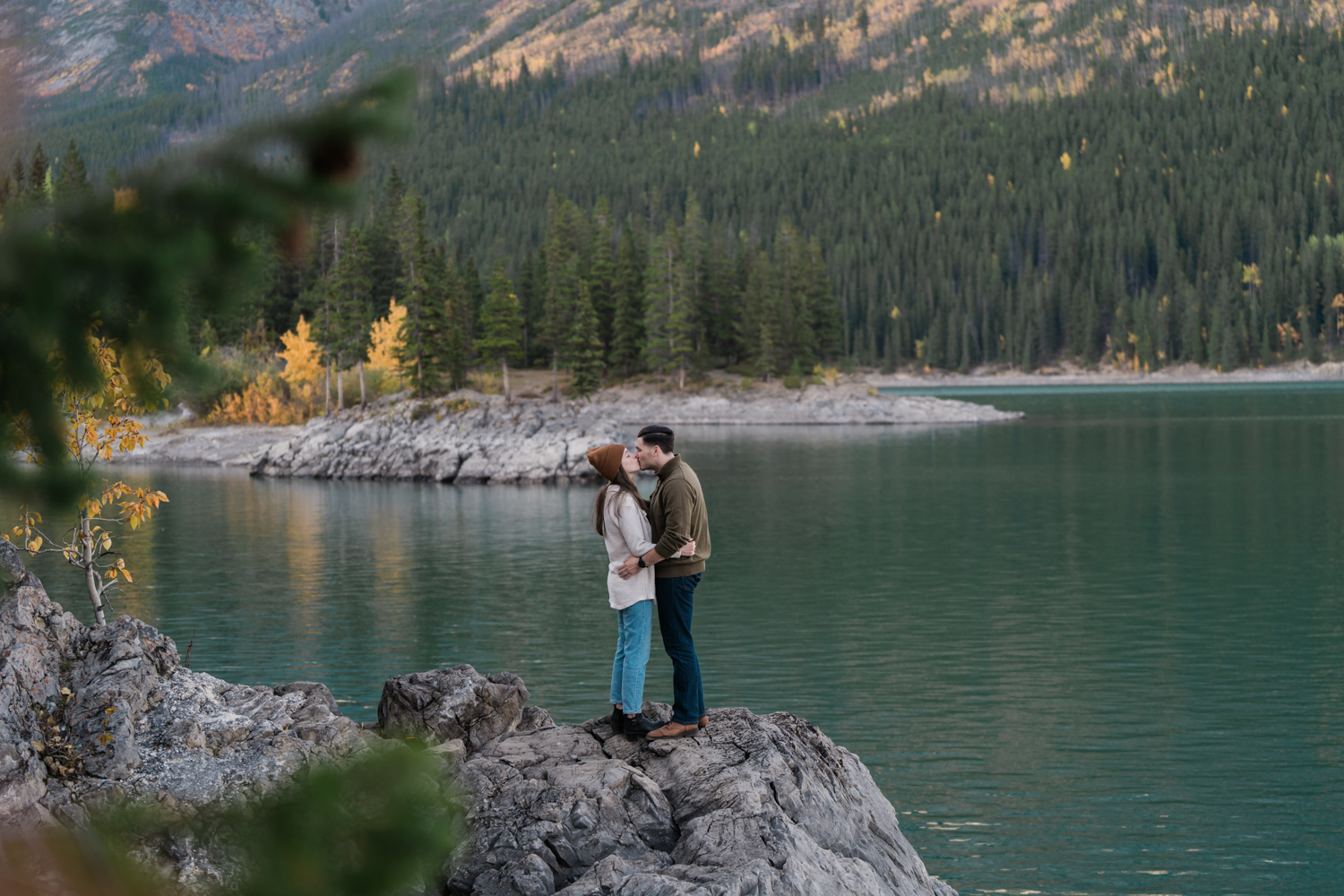Couple kisses during fall Banff engagement photos. 